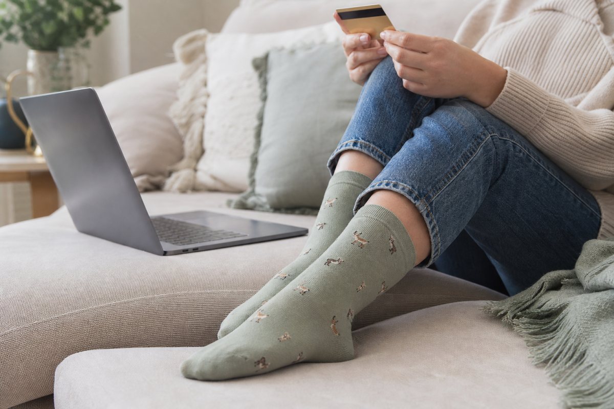 Wearing Bare Kind bamboo socks while shopping online on a laptop at home